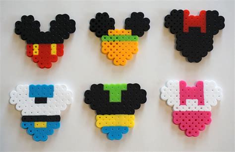 four mickey mouse magnets made out of perler beads on a white surface ...