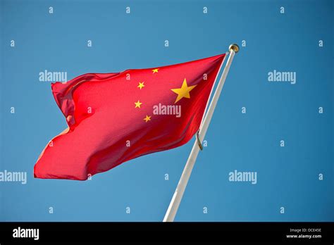 Chinese flag waving in the wind against a blue sky Stock Photo - Alamy