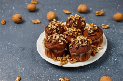 Free Photo | Chocolate-walnut muffins with coffee cup with walnuts on dark surface