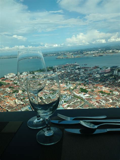 there is a wine glass and utensils sitting on a table overlooking the city