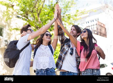 Hip friends doing high five Stock Photo - Alamy