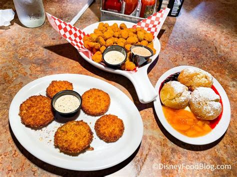 three plates with food on them sitting on a table next to drinks and condiments