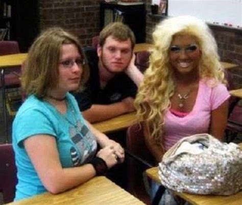 three people sitting at desks in a classroom