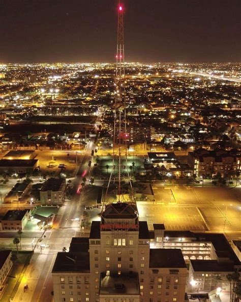 an aerial view of a city at night with the lights on and buildings lit up