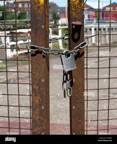 Rusty gates chained and padlocked Stock Photo - Alamy