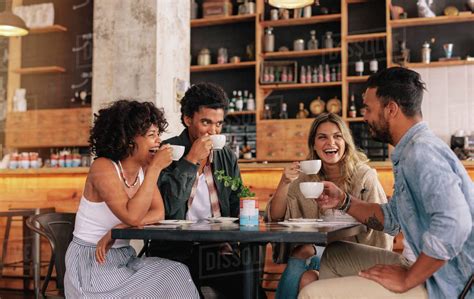 Diverse group of friends enjoying some coffee together in a restaurant ...