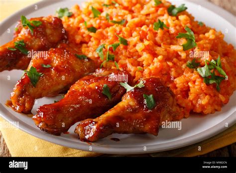 Nigerian food: spicy Jollof rice with fried chicken closeup on a plate. horizontal Stock Photo ...