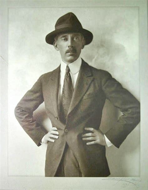 an old photo of a man in a suit and hat with his hands on his hips