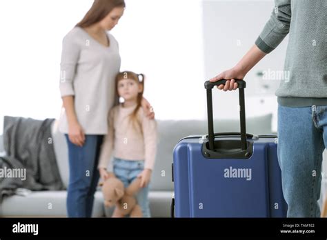 Man with suitcase leaving his family Stock Photo - Alamy