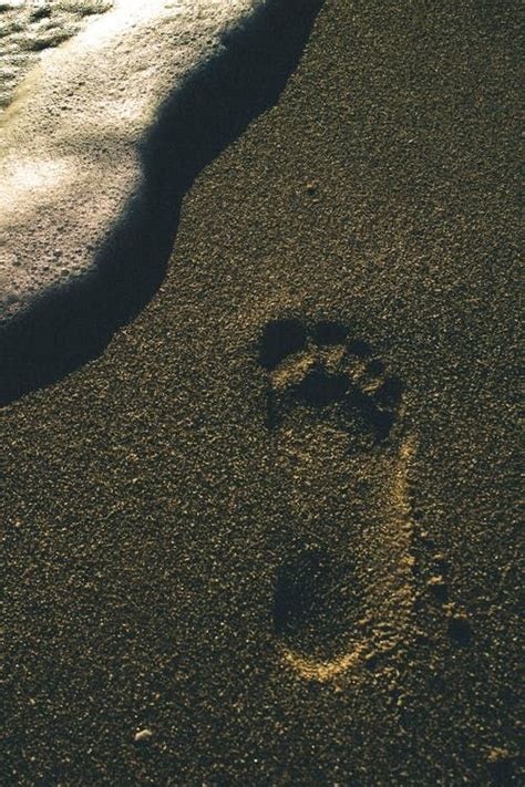 a footprints in the sand next to an ocean