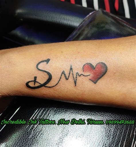 a person with a heart and heartbeat tattoo on their arm that says smr in cursive writing