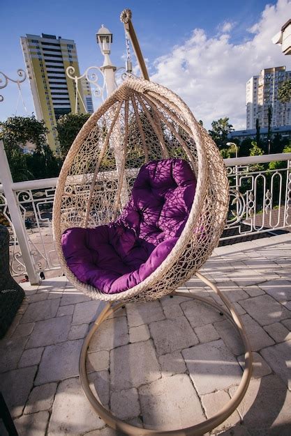 Premium Photo | Hanging chair cocoon with a purple cushion on the ...