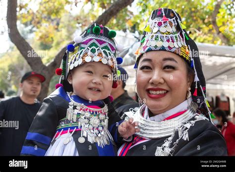 Mother poses with her toddler daughter dressed in traditional attire at the Hmong New Year ...