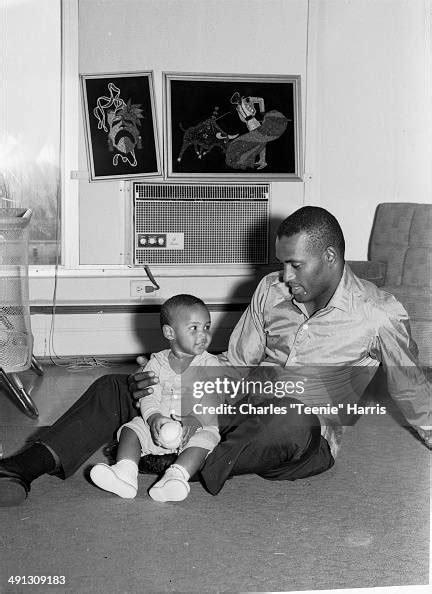 Roberto Clemente and his son Roberto Clemente Jr seated on floor in ...