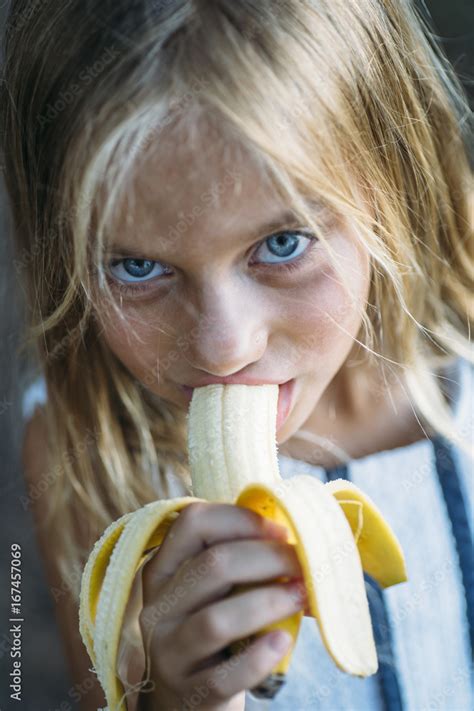 Girl eating banana outside Stock Photo | Adobe Stock