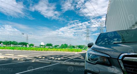 Front view of car parked at parking lot. Shopping mall outdoor car parking area with electric ...