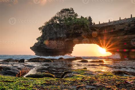 Sunshine through of rocky cliff on seashore at sunset 7304681 Stock Photo at Vecteezy