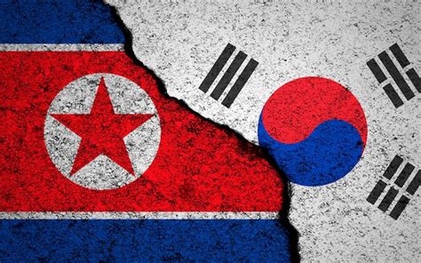 Premium Photo | North Korea and South Korea flags background Cracked ...