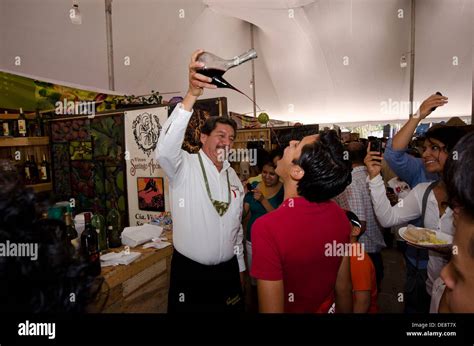 Man pouring wine into another man's mouth at the National Festival of cheese and wine in ...