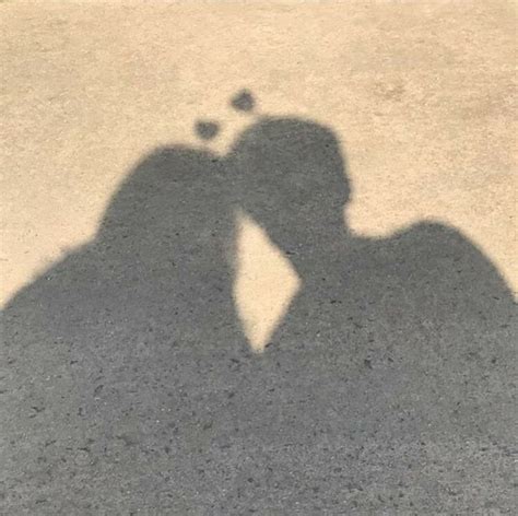 the shadow of two people kissing each other