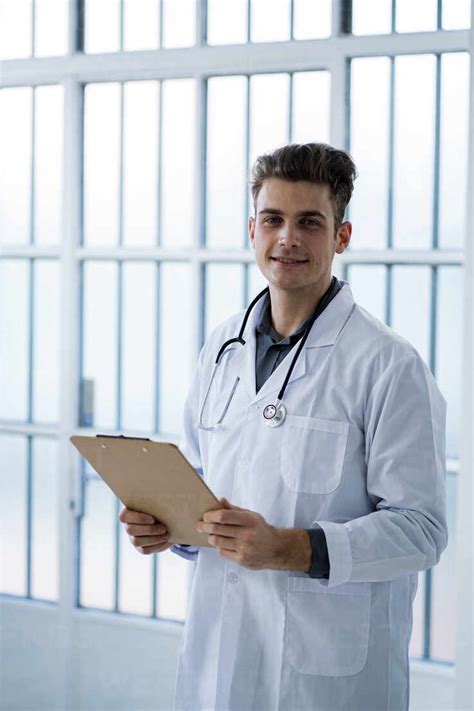 Male doctor holding clipboard in hospital stock photo