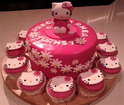 a hello kitty birthday cake with cupcakes on a plate