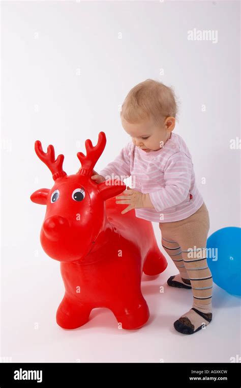 baby playing with red toy elk Stock Photo - Alamy