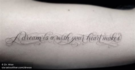 Inner arm tattoo saying "A dream is a wish your heart