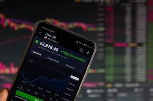 Businessman holds a tablet with holographic graphs showing stock market ...