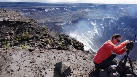 Hawaiian Volcano Observatory scientist installing a new battery in a ...