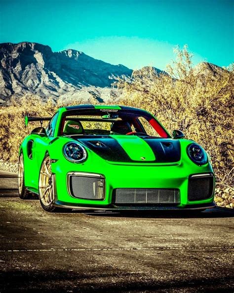 a green sports car parked in front of mountains