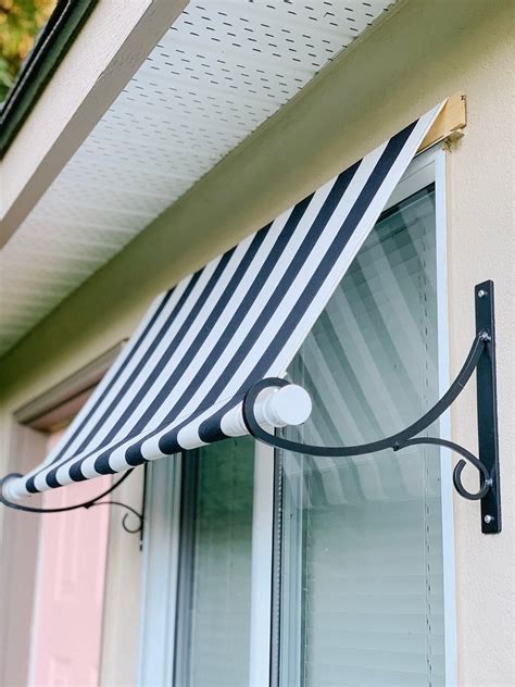 a black and white striped awning hanging from the side of a house