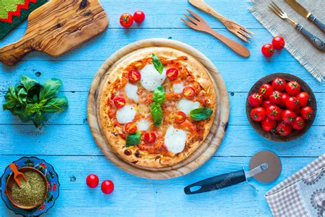 Premium Photo | Top view of italian classic pizza margherita over a wooden table with toppings