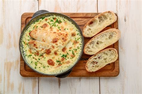 Premium Photo | White fish casserole with cheese, sour cream and onion on a wooden table