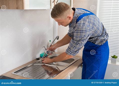 Plumber Fixing Faucet in Kitchen Sink Stock Image - Image of professional, object: 57701559