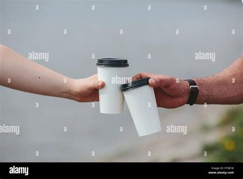 cheers using two cups of coffee Stock Photo - Alamy