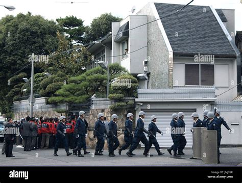 KOBE, Japan - Police officers enter the headquarters of Yamaguchi-gumi ...