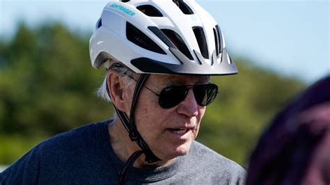 Joe Biden falls while getting off his bike after getting his 'foot caught' following beach ride ...