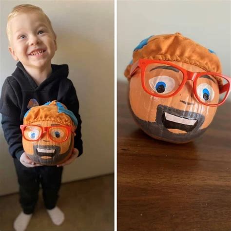 Toddler holding Blippi decorated pumpkin with a Blippi hat and glasses ...