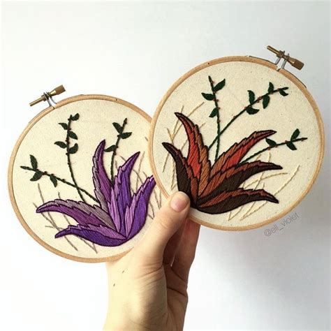 two hand embroidered hoop art pieces with purple and red flowers on ...