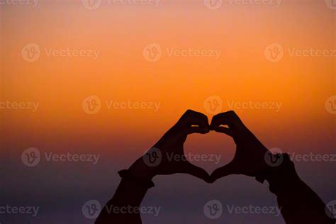 Silhouette of heart made hands at sunset 18038191 Stock Photo at Vecteezy