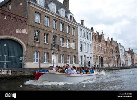 A canal cruise boat taking passengers on a tour of Bruges and its ...