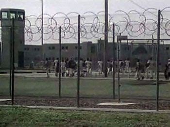 Prison Yard Exercise Area with Guard Tower and Concertina Wire Perimeter