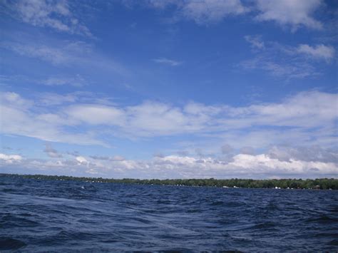 the water is very choppy and blue with some clouds in the sky above it