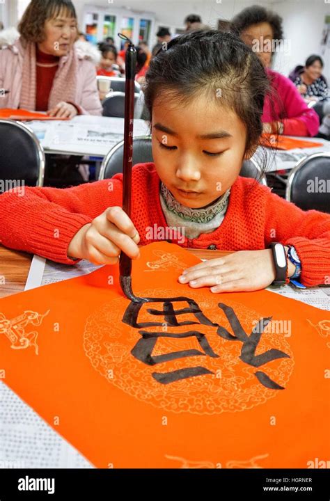 Beijing, China. 12th Jan, 2017. A child writes Chinese character "Fu", meaning happiness ...