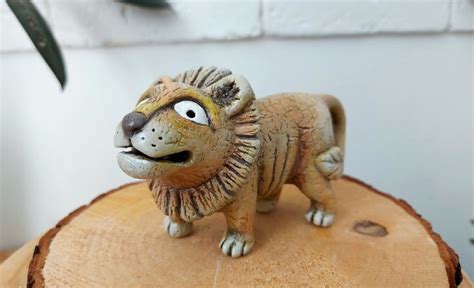 a small lion figurine sitting on top of a tree stump