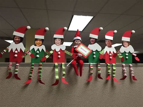 the elfs are lined up in their christmas hats and green pants, with one holding a sign