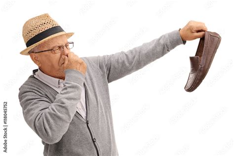 Old man holding a smelly shoe Stock Photo | Adobe Stock