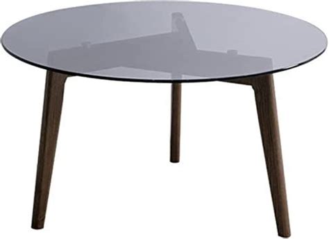 a round glass table with wooden legs