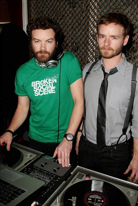 two men standing next to each other in front of a dj's turntable